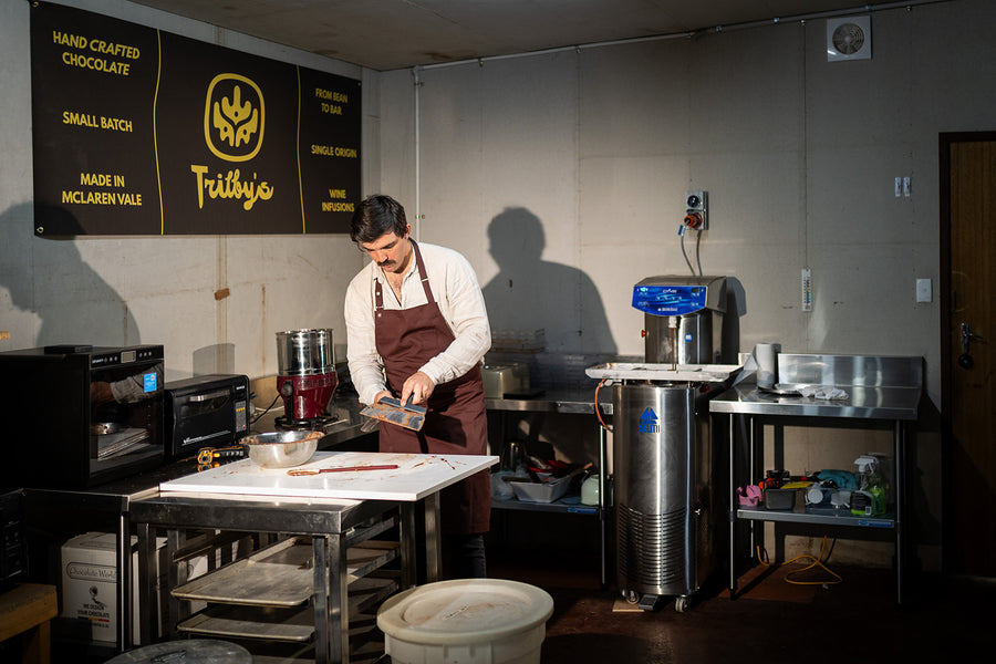 Chocolate maker in an apron working at a bench in the Trilby's chocolate kitchen