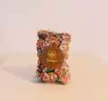 Milk chocolate speckles covered in rainbow sprinkles, in a clear bag with a Trilby's label