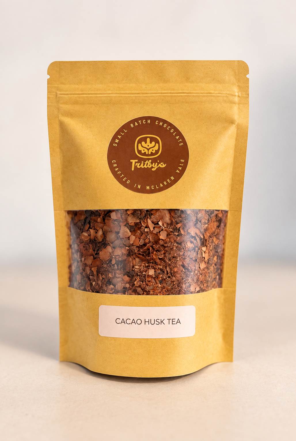 Cocoa Husk Chocolate Tea in a kraft pouch with a window showing the cacao husks