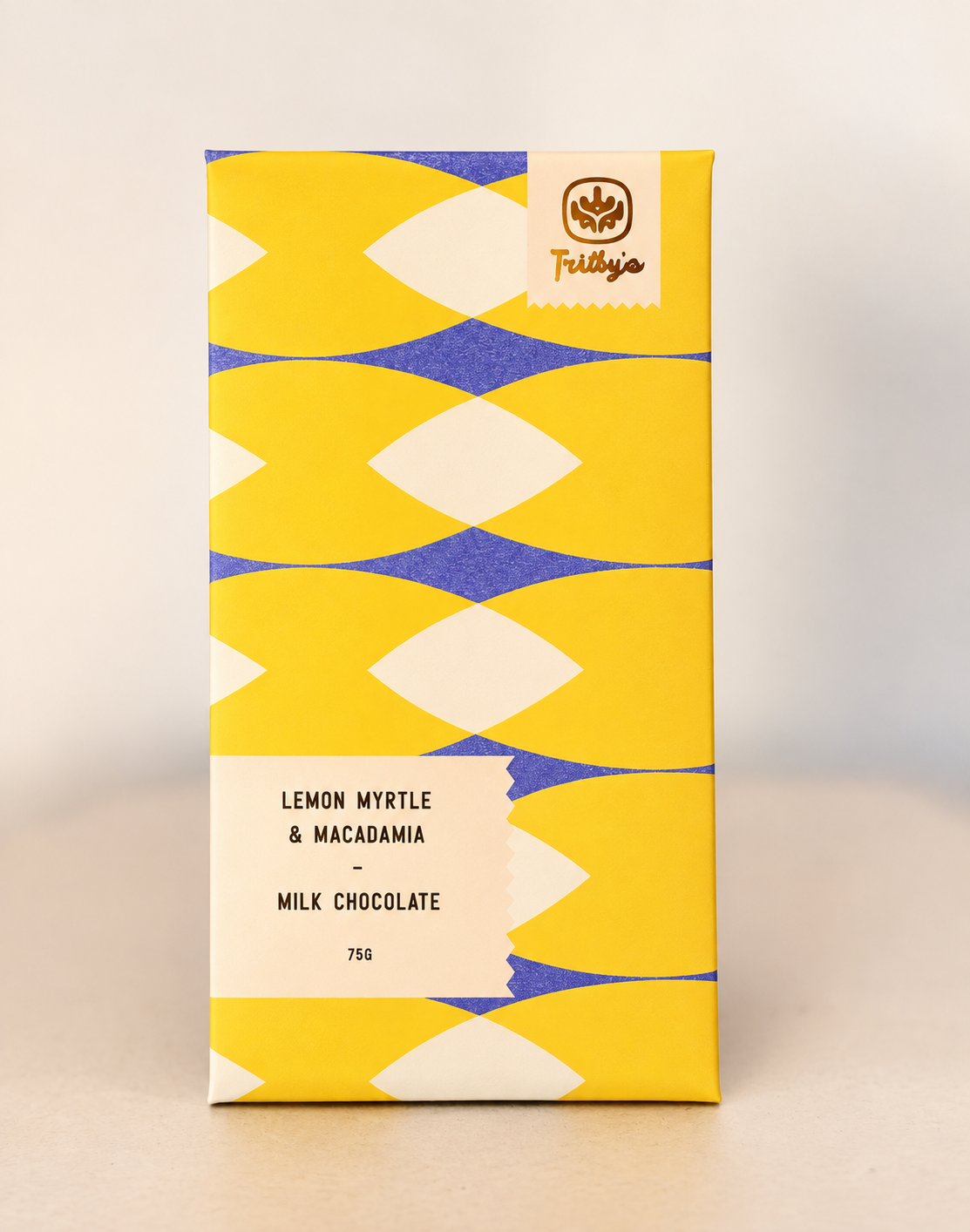 Lemon Myrtle & Macadamia milk chocolate bar in a yellow and blue patterned wrapper