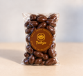 Dark chocolate coated almonds in a clear 200g bag with a round Trilby's label
