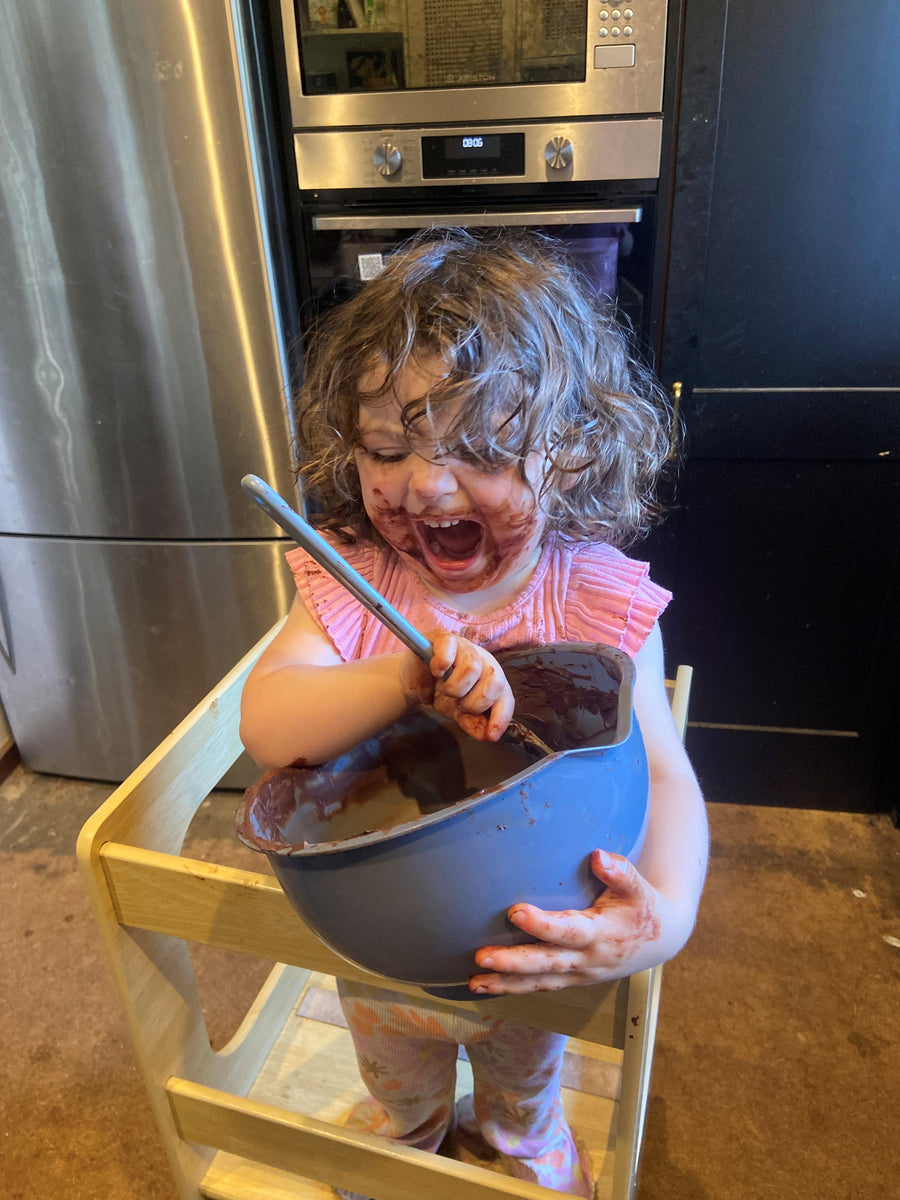 Max's daughter Trilby laughing as she stirs a big bowl of chocolate at home
